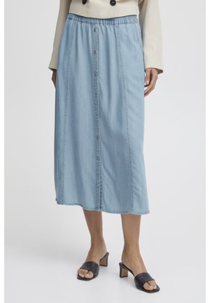 Gonna midi in denim azzurro chiaro con vita elasticizzata, chiusura con bottoni frontali e cuciture laterali. Indossata con tacchi neri a open-toe.
