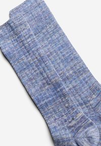 Chaussettes en tricot bleues et violettes avec un motif texturé, dotées d'une bordure côtelée et d'un orteil renforcé, fabriquées dans un matériau doux et flexible.