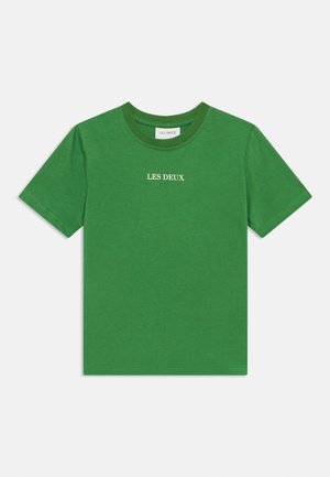 Roheline lühikeste varrukatega puuvillane T-särk ümar kaelusega. Rinnal valgest heegeldatud kiri "LES DEUX". Lihtne, ühtlane tekstuur.