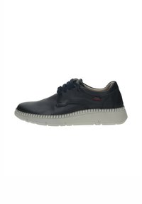 Zapato de cuero azul marino con punta redonda, acentos texturizados y cordones azules. Presenta una suela de goma blanca con detalles de costura a lo largo del borde.
