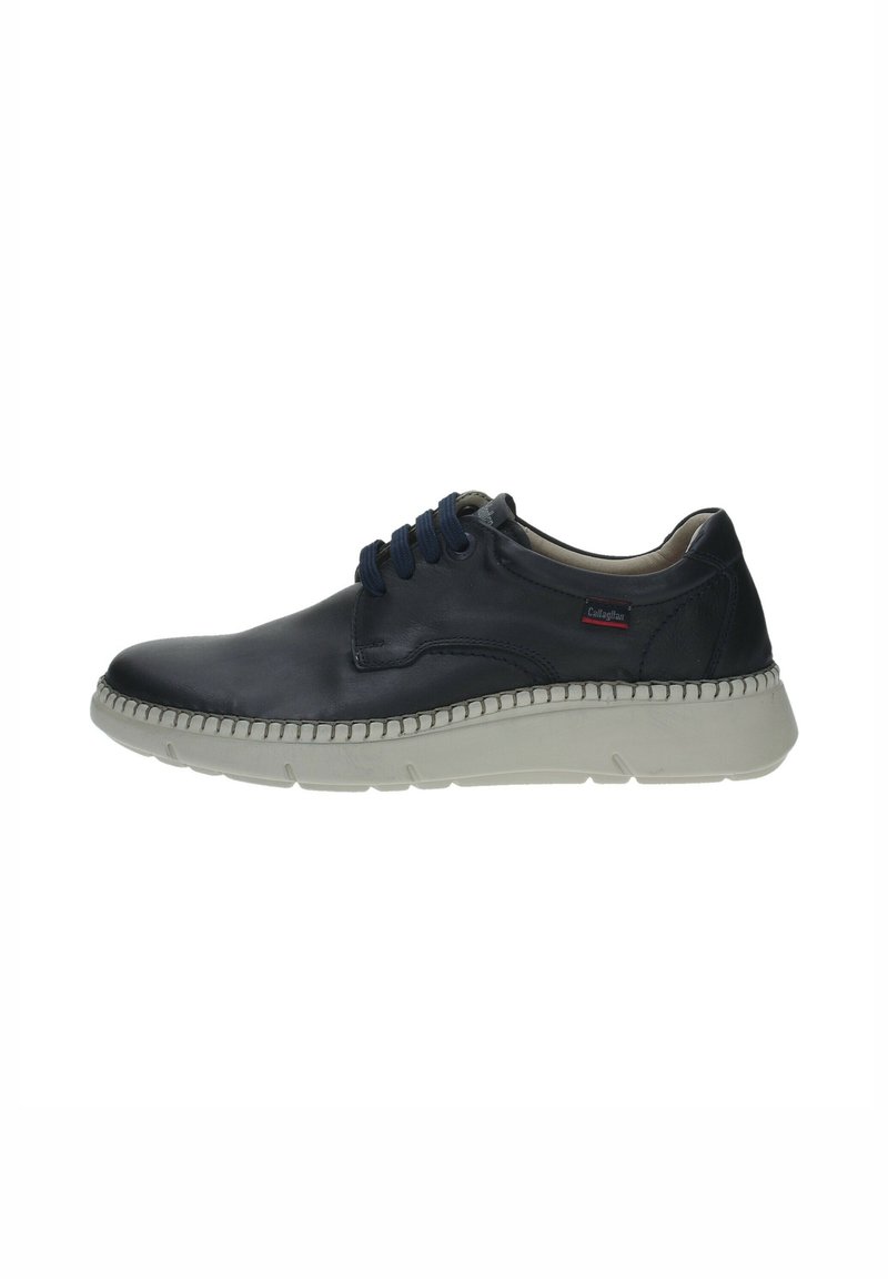 Zapato de cuero azul marino con punta redonda, acentos texturizados y cordones azules. Presenta una suela de goma blanca con detalles de costura a lo largo del borde.