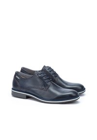 Leather lace-up shoes in navy blue with a smooth finish, contrasted stitching, and a textured interior lining. Features a white rubber sole.
