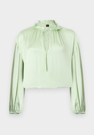 Světlý zelený dlouhý rukáv halenka s volánovým vysokým límcem s tkaničkou, nařasenými manžetami a hladkým, mírně lesklým materiálem.