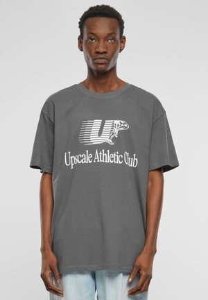 Grå bomulds T-shirt med korte ærmer, der har et hvidt grafisk design med teksten "Up" og "Upscale Athletic Club". Løs pasform.