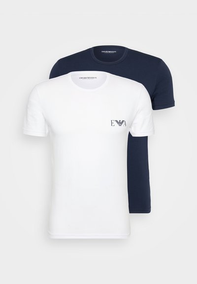 Deux t-shirts à manches courtes : un blanc avec un petit logo imprimé et un bleu marine. Les deux sont en tissu de coton doux.