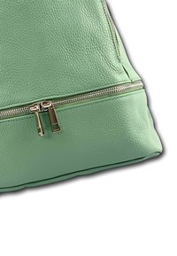 Sac à main en cuir vert menthe avec une surface texturée et une double fermeture à glissière avec des accessoires en argent. Forme angulaire et bords renforcés.