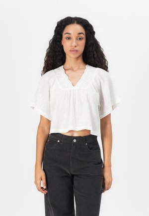 Gekürzte, weiße Bluse mit V-Ausschnitt und besticktem Spitzenbesatz, die kurze, ausgestellt Ärmel und einen leichten, strukturierten Stoff aufweist.