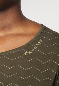 Olivově zelené tričko s kulatým výstřihem, malými světle modrými květinovými vzory a zlatým nápisem "dogwear".