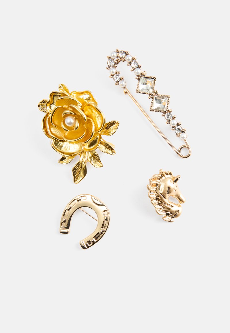 Guldtonet brosche sæt, der inkluderer en rose med perle, en krystalnål, en hestesko og et enhjørningehoved. Forskellige teksturer og intrikate design.