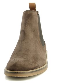 Stivale Chelsea in suede marrone con pannelli elasticizzati ai lati e un risvolto. Presenta una punta arrotondata e una leggera suola in gomma. Texture liscia.