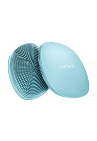 Blaue ovale Silikon-Gesichtsreinigungsbürste mit weichen Borsten, Vorder- und Rückseite gezeigt, mit der Marke "GESKE" auf der glatten Seite.