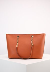 Grande borsa a tracolla arancione realizzata in pelle testurizzata con manici in catena dorata e dettagli neri. Presenta un design spazioso per un'ampia capacità di stoccaggio.