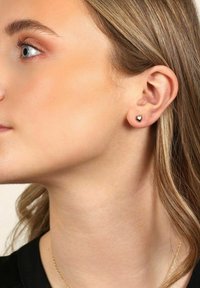 Hjärtförsedda studs i glänsande silvermetall, som sitter tätt på örsnibben. Enkel design med en polerad yta.