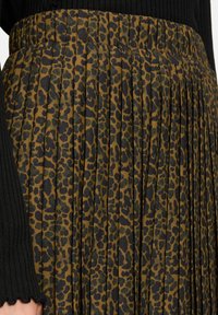 Gonna plissettata con un motivo leopardato marrone e nero, realizzata in un tessuto testurizzato e con una ampia fascia elastica in vita.