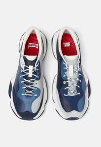 Sneaker blu e grigio con un design a strati, caratterizzato da una combinazione di texture in pelle e scamosciato, dettagli riflettenti e solette rosse a contrasto.