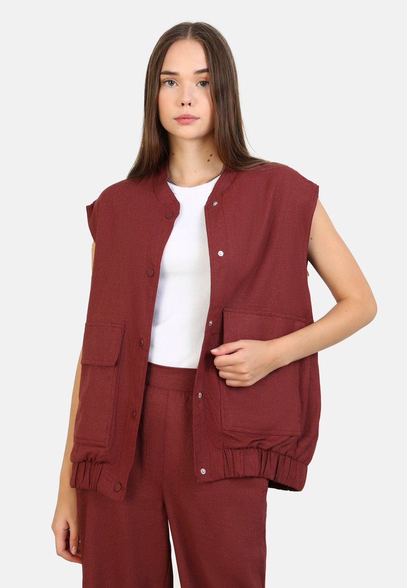 Burgunderröd ärmlös väst med rund halsringning, tryckknappar och två framfickor; textil med struktur och elastiska manschetter.