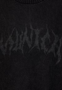 Pull noir en maille avec un motif texturé et un logo subtil dans des tons plus foncés, col rond et poignets côtelés.