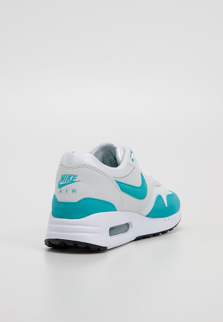Nike Air sneaker met een wit en turquoise kleurenschema, voorzien van een bovenwerk van suede en mesh, zichtbare luchtkussens en een gestructureerde rubberen zool.