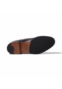 Scarpa in pelle marrone con suola in gomma nera. Cuciture visibili sul lato e superficie superiore liscia con punta leggermente arrotondata.