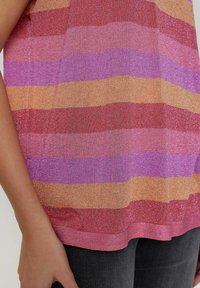 Camiseta de rayas multicolores que presenta bandas horizontales de rojo, rosa, naranja y púrpura con una textura ligeramente brillante y un dobladillo redondeado.