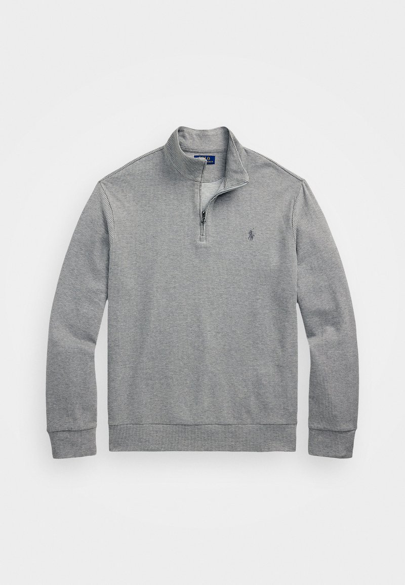 Grå strikket genser med kvart-glidelås krage, ribbestrikkede mansjetter og hem. Har en liten logo på brystet og et teksturert mønster.