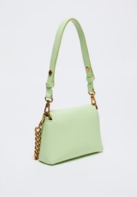Borsa sintetica verde chiaro di forma rettangolare, con tracolla e dettagli in catena dorata. Texture liscia, design minimalista.