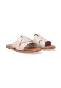 Lichtbeige glijdersandalen met kruissluiting, leren bovenwerk, open teen, platte zool en tan inlegzool. Minimalistische stijl met zilveren accenten.