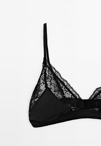 Czarny biustonosz braletka z koronkowym wykończeniem, miękkiego materiału, regulowanymi ramiączkami, w kształcie litery V oraz bezszwowym podszyciem dla komfortu.