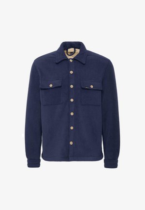 Marinblå fleece skjortjacka med två bröstfickor, knäppningar och en krämfärgad foder. Har en klassisk krage och mjuk textur.