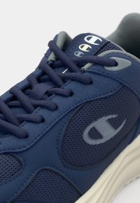 Navy athletic shoe with mesh and synthetic upper, featuring tonal laces, padded collar, and logo accents in light gray. Rubber sole.