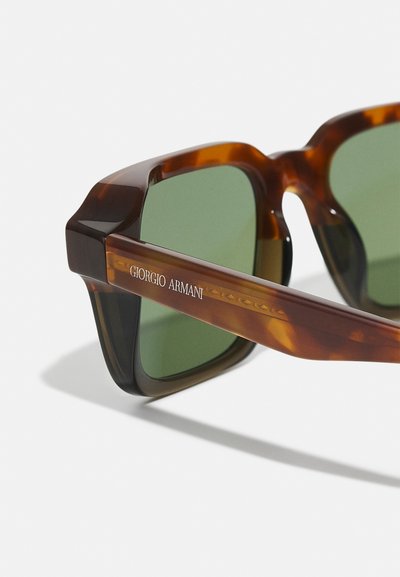 Želvovinové sluneční brýle se zelenými skly a silnými čtvercovými rámy, s názvem značky "Giorgio Armani" po straně v stříbrném písmu.