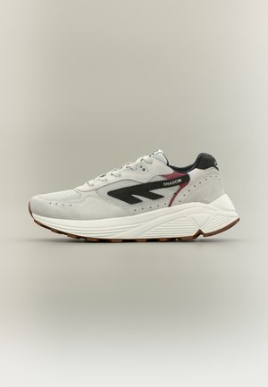 Light gray sneaker with black and maroon accents, "SHADOW" text on side, white textured sole, and brown rubber outsole.