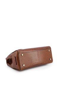 Rektangulær brun håndtaske i krokodillemønsteret læder set fra bunden, der viser fire golde metalfødder og et brandlabel.