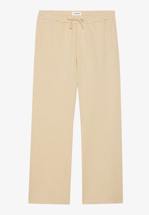 Pantalones de pierna ancha beige, fabricados en un tejido suave, con una cinturilla elástica y cordón ajustable, y dos bolsillos laterales. Textura suave.
