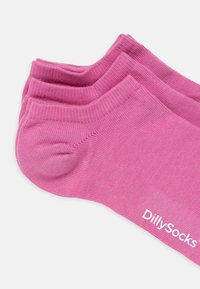Lyserøde ankelstrømper lavet af blødt stof, med ribbet tekstur og mærkenavnet "DillySocks" trykt i hvidt på siden.