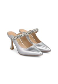 Srebrne lakierowane czółenka na wysokim obcasie z wąskimi noskami oraz strapem zdobionym kryształkami przewijającym się przez łuk stopy. Wąskie obcasy typu stiletto.