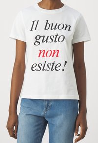 Biała bawełniana koszulka z czarnym i czerwonym napisem: "Il buon gusto non esiste!" Krótkie rękawy i luźny krój.