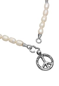 Perle halskæde med off-white, ovalformede perler og sølvhardware; inkluderer et rundt fredssymbol vedhæng med indskrift.
