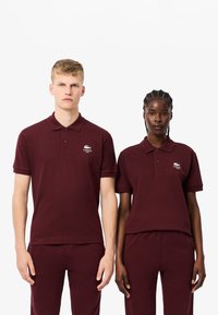 Bordowe koszulki polo z miękkiej bawełny, z klasycznym kołnierzykiem, krótkimi rękawami oraz haftowanym logo na lewej piersi.