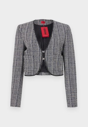Cropped jacket in woven navy and white fabric. Features a rounded neckline, hook closure at the front, and long sleeves. Includes a tag.