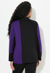 Svart och lila färgblockerat linne med långa ärmar, som har en avslappnad passform och mjuk textur, designat med krage och sidosprund.