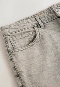 Grijze denim jeans met een voorzak, gestikte details en een vervaagde textuur met een licht versleten afwerking.