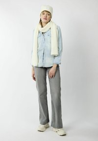 Lichtblauwe denim shirt, off-white geribde brei muts en sjaal, grijze flared jeans en witte sneakers. Eenvoudige en casual outfit.