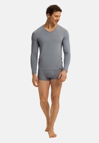 Grijze lange mouw V-hals shirt en bijpassende slips, gemaakt van een gladde, rekbare stof. Heeft een aansluitend ontwerp en subtiele branding.
