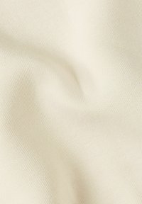 Katoenen stof in een lichte crème kleur, met een zachte, gladde textuur en een fijn, consistent weefpatroon over het oppervlak.