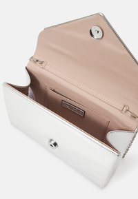 Srebrny metaliczny kopertówka o gładkiej powierzchni. Wnętrze wykończone beżowym materiałem, posiada kieszeń na karty oraz łańcuszek z zapięciem na zatrzask.