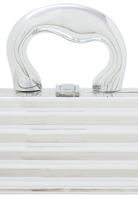 Metallic sølv håndtaske med et buet, bølgeformet håndtag. Har et vertikalt rippet design og en låsemekanisme øverst. Kompakt og struktureret.