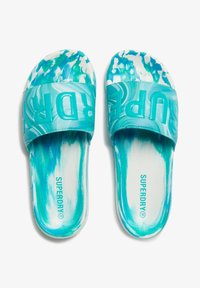 Aqua blue slide sandals with a glossy strap, featuring "SUPERDRY" embossed. Marbled pattern on the footbed, smooth texture throughout.