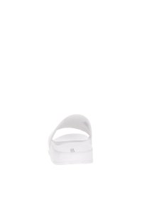 Sandal in bianco con suola liscia e piatta, design a fascia ampia e aperta, e fondo texturizzato per il comfort. Costruzione e stile minimalisti.