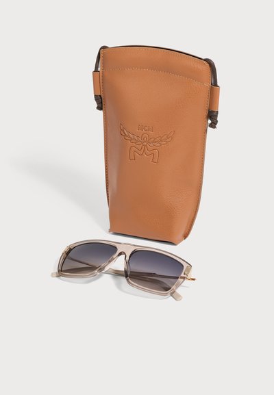 Pochette à lunettes de soleil MCM en cuir marron avec cordon de serrage et lunettes de soleil rectangulaires avec montures beiges translucides et verres foncés.